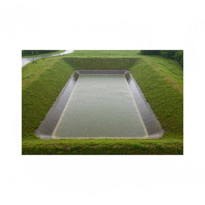 Aerial view of a detention basin during a light rain, showing water collecting and slowly infiltrating, surrounded by green landscape, no text, no words, no typography, clean image